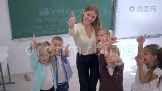 快乐的小学生，老师在教室里以黑板为背景竖起大拇指视频