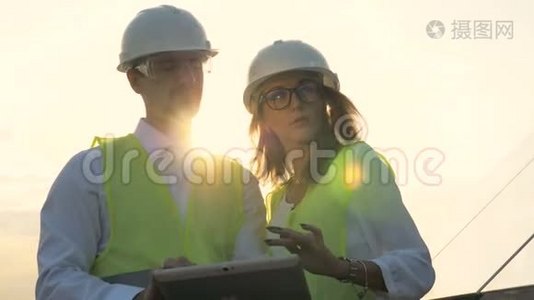 在太阳能电池板附近工作的男女太阳能视察员。视频