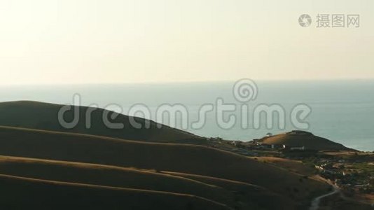 在夏季的夜空下，在背景上鸟瞰高绿色的山丘和蓝色的大海。 奇妙的色彩视频