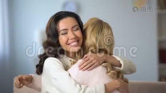 两位年轻女子拥抱在一起，真诚地微笑着，真诚的友谊，在室内视频