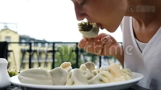 一个年轻的女人在餐馆里用手在盘子里端着菠菜吃卡卡利菜，动作很慢视频