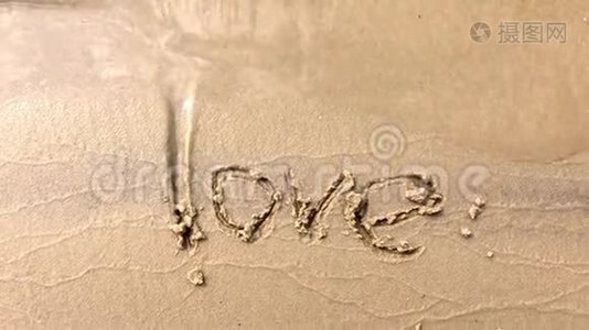 在沙滩上漂浮的海浪的俯视图，爱这个词就是在沙滩上写的视频