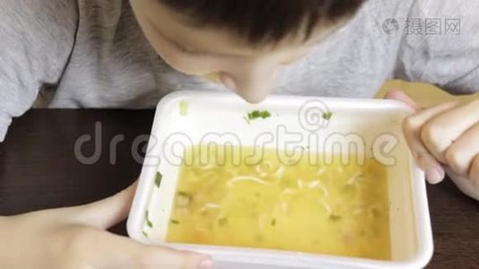 一个十几岁的白种人男孩在家吃中国快餐，从一次性容器里的方便面视频
