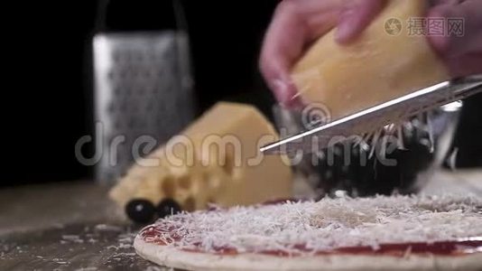 厨师用金属磨碎器在一个大比萨饼上用番茄酱摩擦奶酪。 意大利自制比萨饼的传统配方视频