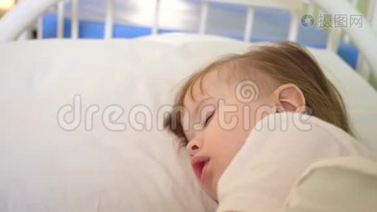 幼儿睡在医院病房的白色被褥上，用温度计测量体温.. 对儿童的治疗视频
