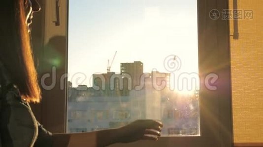 城市日落时，一位年轻女子走到窗前关上窗帘视频