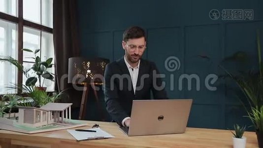 男设计师在办公室与模型屋笔记本电脑工作。视频