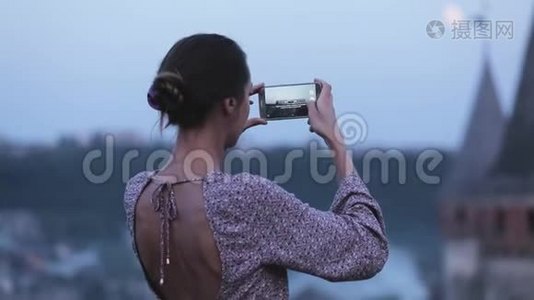 一位年轻美丽的黑发女子在手机上拍摄视频的肖像视频