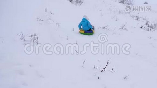 冬天，女孩骑着雪碟从高山上飞过雪地，快乐地笑着。 快乐的女人在哭泣视频