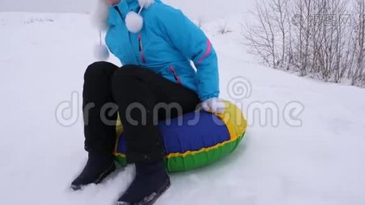 冬天，女孩骑着雪碟从高山上飞过雪地，快乐地笑着。 快乐的女人在哭泣视频