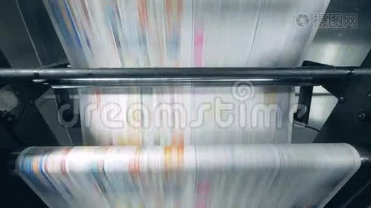印刷报纸在传送带上滚动，印刷设备工作。视频