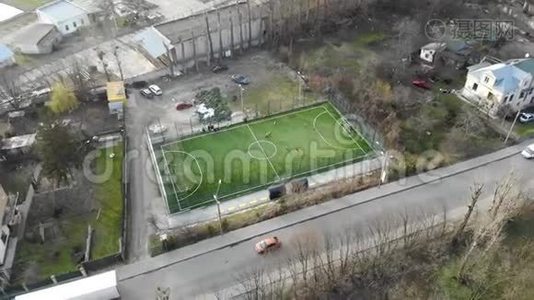 足球场地在城市中部设有人工草皮和围栏.. 孩子们踢足球视频