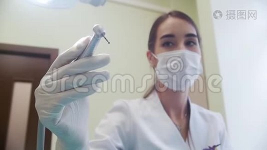 女牙医拿着一个牙科冲洗器工具打开它。 牙医`办公室视频