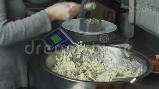 厨师在厨房`的餐馆里把一份肉沙拉和蔬菜放在盘子里视频