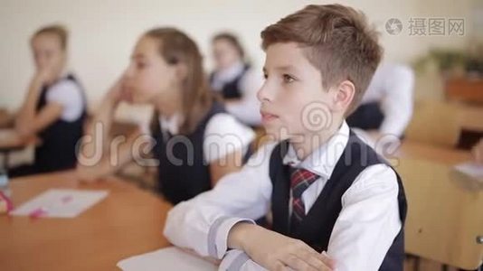 穿着校服的高中生坐在教室里专心听讲座视频