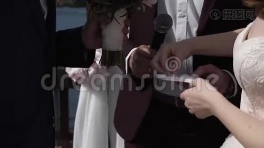 新娘在婚礼上给新郎戴上结婚戒指。视频
