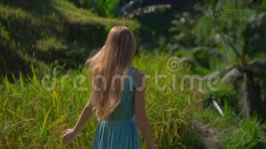 一位穿着蓝色裙子的年轻美女慢镜头来到乌布德村著名的tegalang米梯田。视频