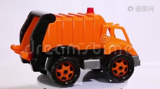 橙色玩具车库卡车秤模型车在白色背景下旋转。视频