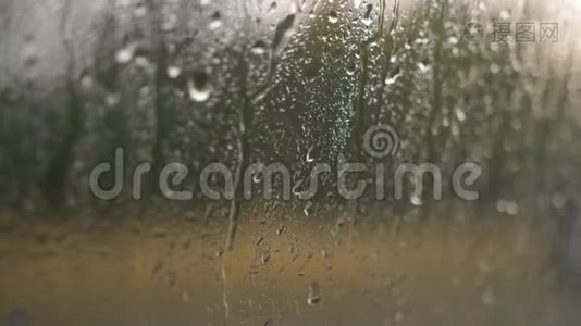 在夏季的阵雨中，玻璃上的水滴特写，大的雨滴撞击窗户玻璃。视频