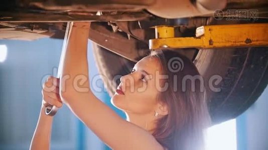 机械师女孩用扳手修理汽车。 关门视频