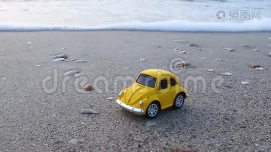 旅行和度假。 玩具黄车在沙滩上靠海..视频