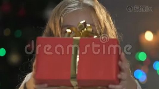 可爱的女孩展示大红盒子与蝴蝶结相机赠送圣诞礼物视频