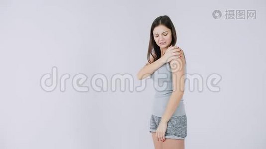 年轻女子肩膀疼痛，关节疼痛，白色背景孤立视频