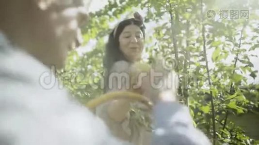 微笑成熟的女人把苹果递给她的丈夫。 慢动作视频