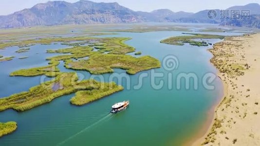 摩托艇漂在河上，旁边是沙岸.. 达兰河和伊兹图祖河。 背景中的山脉视频