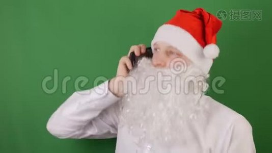 像圣诞老人一样的男人紧张地在电话里，在绿色的Chroma键上交谈视频