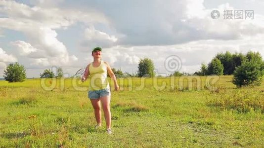 一个在空地上打羽毛球的女人发球和击球视频