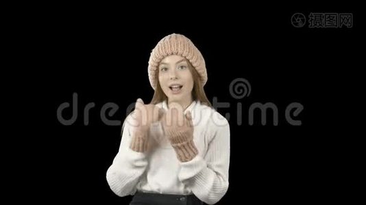 一个可爱的红发少女，戴着一顶粉色针织帽子和洋娃娃，展示着一些东西，微笑或钦佩视频