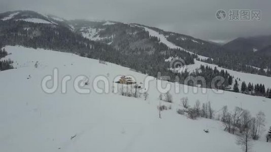 飞越喀尔巴阡山的一个村庄。 鸟`山上白雪覆盖的房子的视野。 乡村景观视频