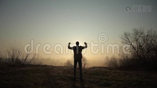 快乐成功的人在日出或日落时庆祝。 快乐自由。 他举起双手，再次欢呼视频