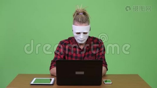 黑皮斯特人戴着面具当黑客，同时还要对木制桌子进行多重任务视频