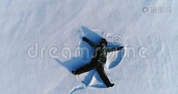 七岁男孩做雪天使，空中镜头视频