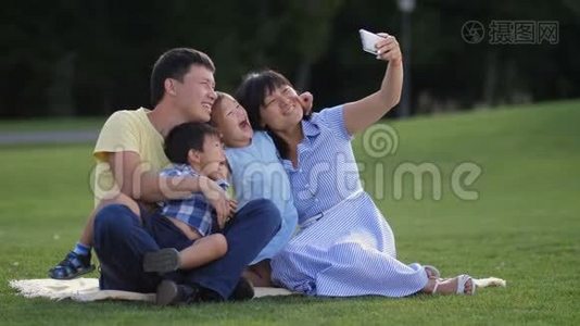 欢乐的亚洲家庭和孩子们在公园自拍视频