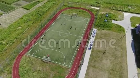 鸟瞰儿童在一个小足球场上踢足球.. 学校附近的现代足球场视频
