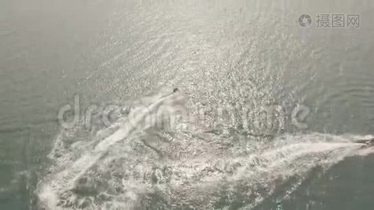 人们乘坐水上喷气式滑雪板在蓝色的海洋在日落鸟瞰。 Drun看到人们在露天水中驾驶喷气式滑雪板视频