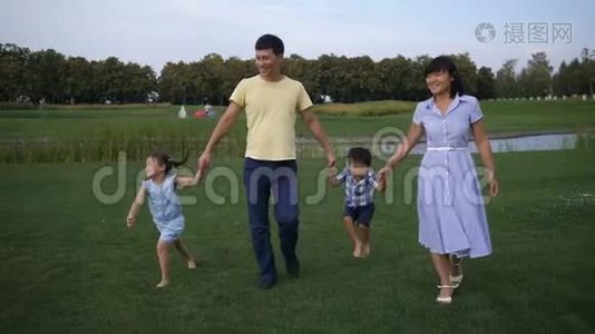 欢乐的亚洲家庭牵手漫步公园视频