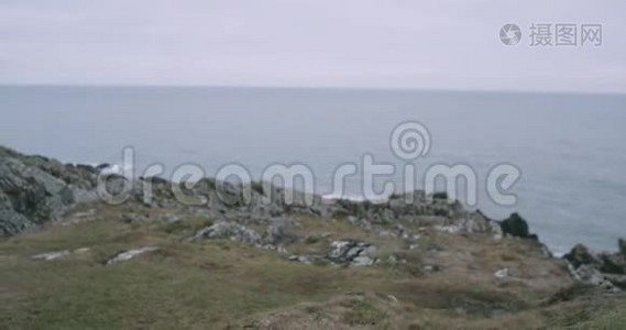 镜头前特写游客漫步到山岸，欣赏山海景观..视频