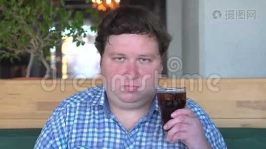 胖子在咖啡馆里喝着一杯可乐，摇头说是的视频