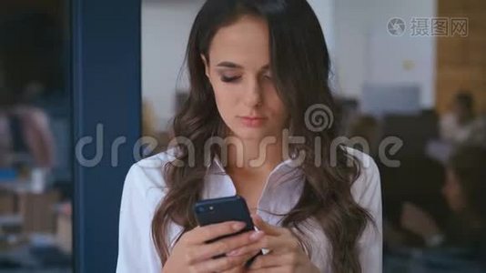 一位年轻漂亮的商务女性，后台办公室里有智能手机发短信视频