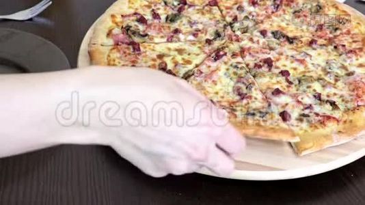 女人坐在桌子旁，拿着一块美味的披萨，放在盘子里视频