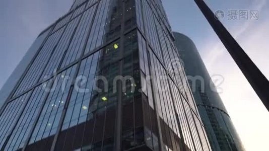 不寻常形状的现代摩天大楼，由玻璃制成。 在旋转中观看。 白天视频