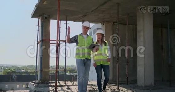 一栋在建建筑的主管，男子与工程师、设计师妇女讨论施工进度和视频