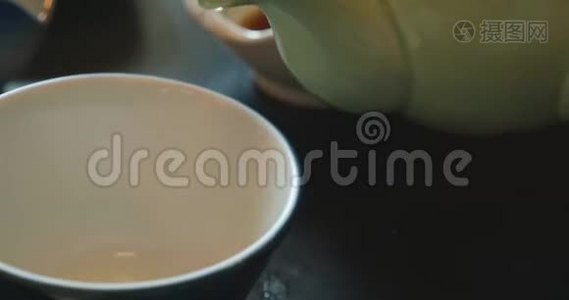 在日本，绿茶从茶壶倒到杯子-特写视频