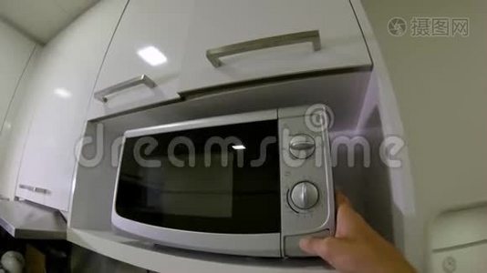 一个男人在厨房里用微波炉慢镜头视频