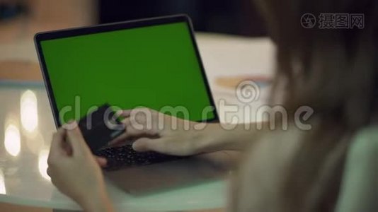 女士在带有绿色屏幕的笔记本电脑上输入信用卡数据视频