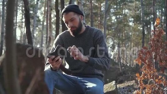 小胡子在森林里砍斧子。 粗鲁的男人坐在户外用斧头。视频